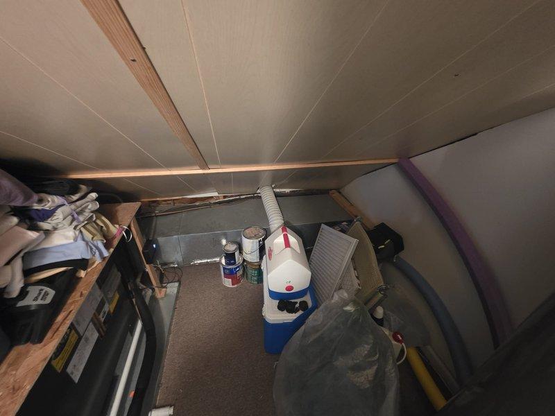 Completed comfort call and attic space inspection. Documented current storage conditions in accessible attic crawl space with sloped ceilings and exposed wooden framing. Photographed existing layout including stored items, household belongings, and various containers throughout the space. Verified adequate lighting and structural accessibility. White flexible ductwork observed running through storage area with no visible obstructions or damage noted at time of inspection.