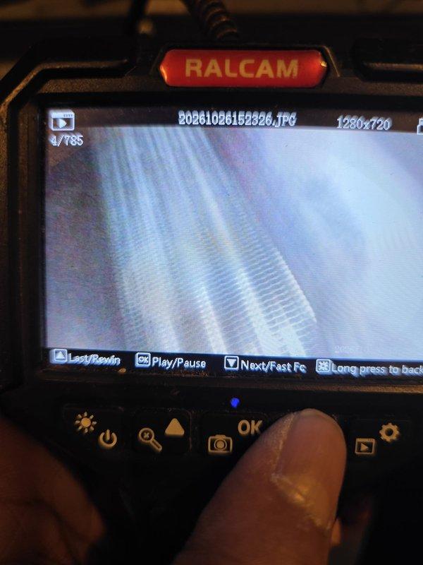 Performed a borescope inspection of the HVAC system's internal components, including the finned heat exchanger/coil surfaces and the interior of the metal housing, to assess condition and identify contamination. Documented interior views showing residue and staining near the housing port and surrounding surfaces, and captured high-resolution images for the service record to support further cleaning and maintenance recommendations.