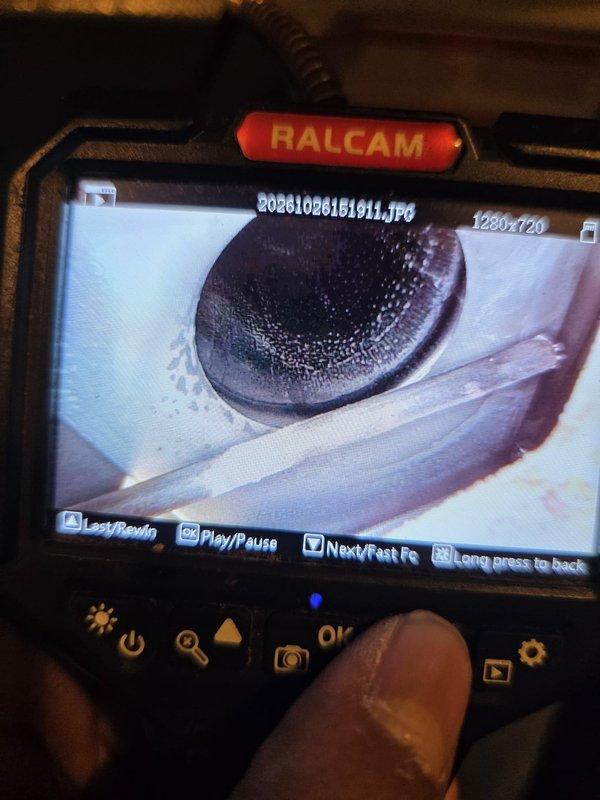 Performed a borescope inspection of the HVAC system's internal components, including the finned heat exchanger/coil surfaces and the interior of the metal housing, to assess condition and identify contamination. Documented interior views showing residue and staining near the housing port and surrounding surfaces, and captured high-resolution images for the service record to support further cleaning and maintenance recommendations.