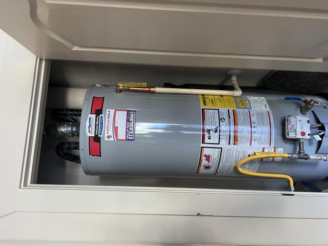 Rheem tank-style propane water heater installed in a utility closet, showcasing installation details and safety labels, relevant to plumbing services in Lakeway, TX.