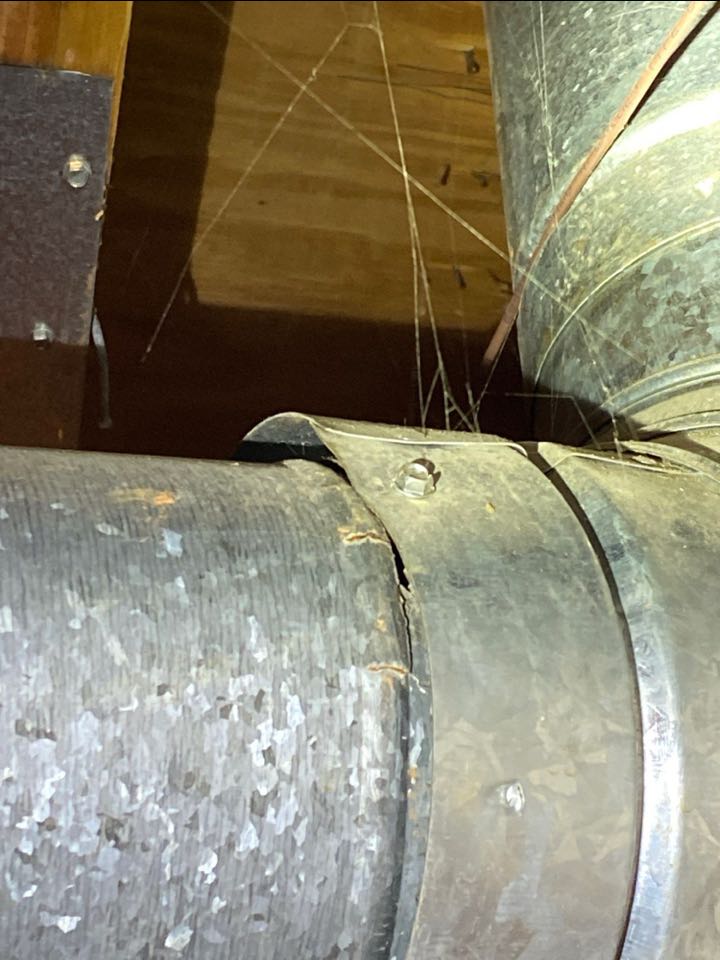Cracked and rusted flue pipe needs replaced for safety.