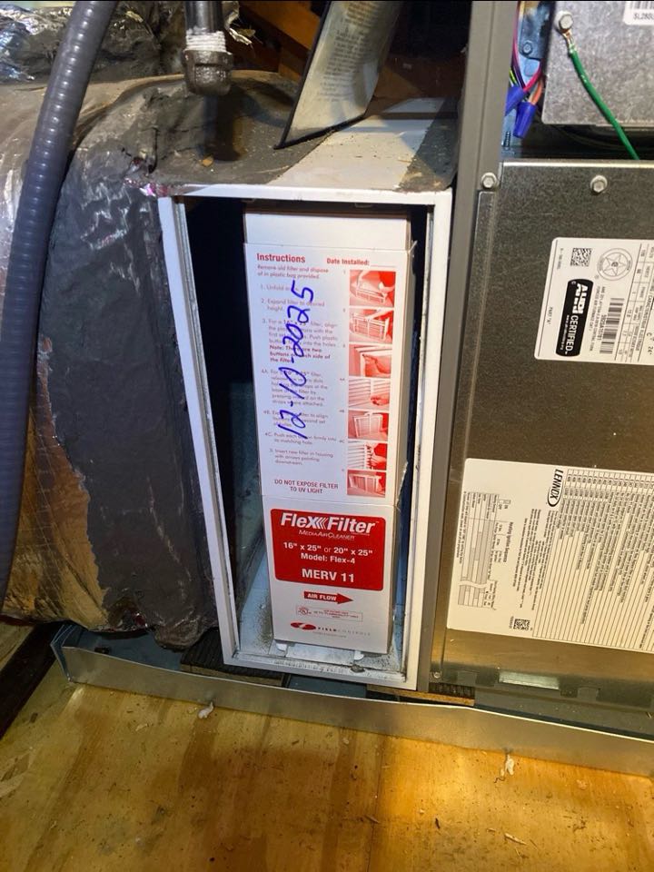 Media filter replacement during gas furnace heat maintenance.