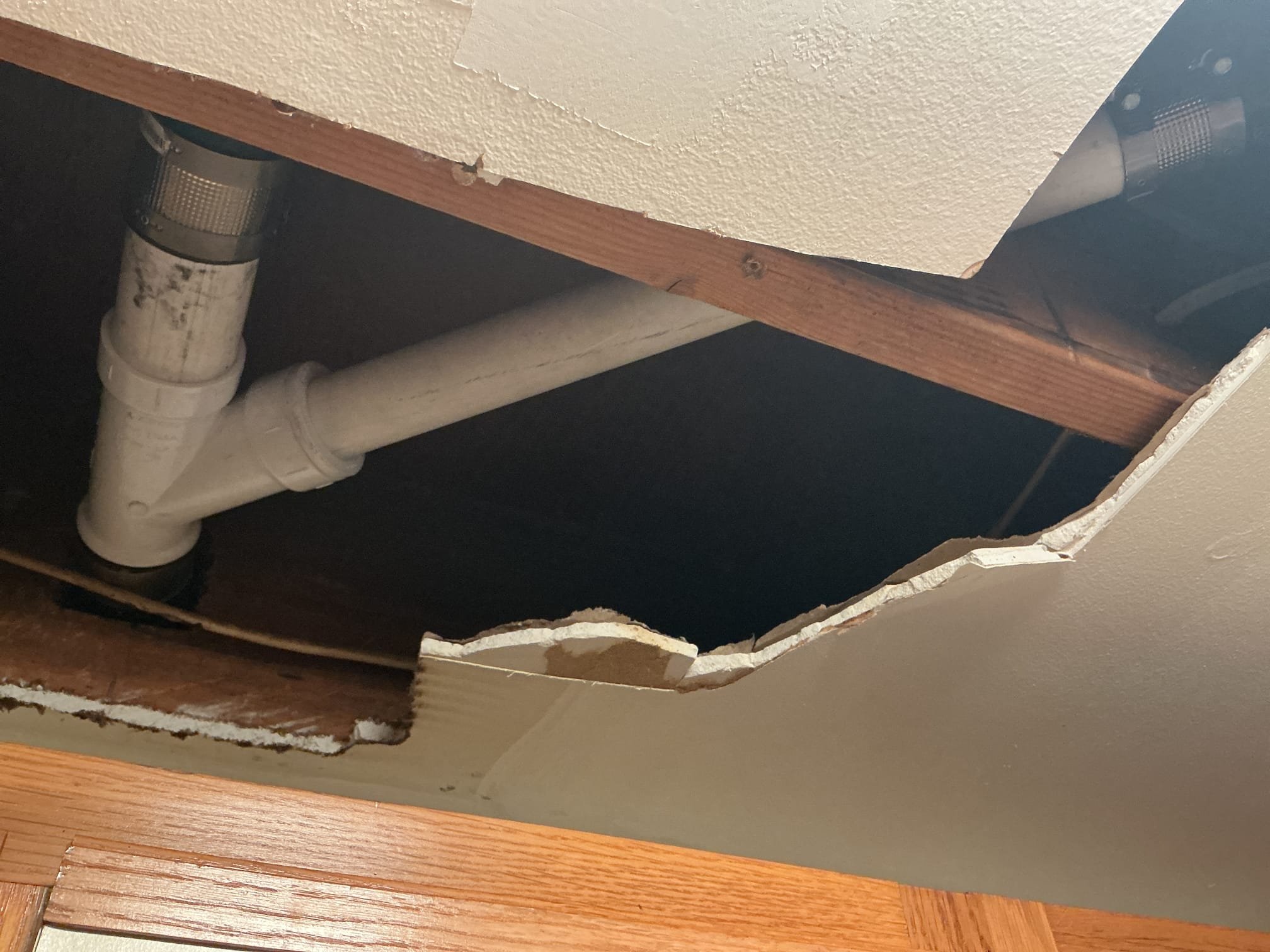 Arrived to the home, customer states there is a leak from the upstairs going down to the first floor, home is a bi level style house. Customer states it leaks worse when the dishwasher is ran in the kitchen upstairs and the leak appears to be coming from the supply register above the fridge on the first floor. After removing the supply register, I discovered an ABS drain pipe has a fracture crack resulting in the leak. After cutting the pipe I discovered a major amount of grease caked up in the piping. With the pipe not be supported correctly the weight of the grease appeared to create the crack. I then spoke to the customer and they would like to go through with the repair.

Cut a portion of the Sheetrock to expose the broken pipe.
Cut out and removed the broken pipe pipe and fittings from the home.
Prepped piping for new install.
Supplied and installed new PVC pipe and fittings.
Supported the piping.
Secured all my connections.
Ran water in both bathtub and kitchen sink to check for 