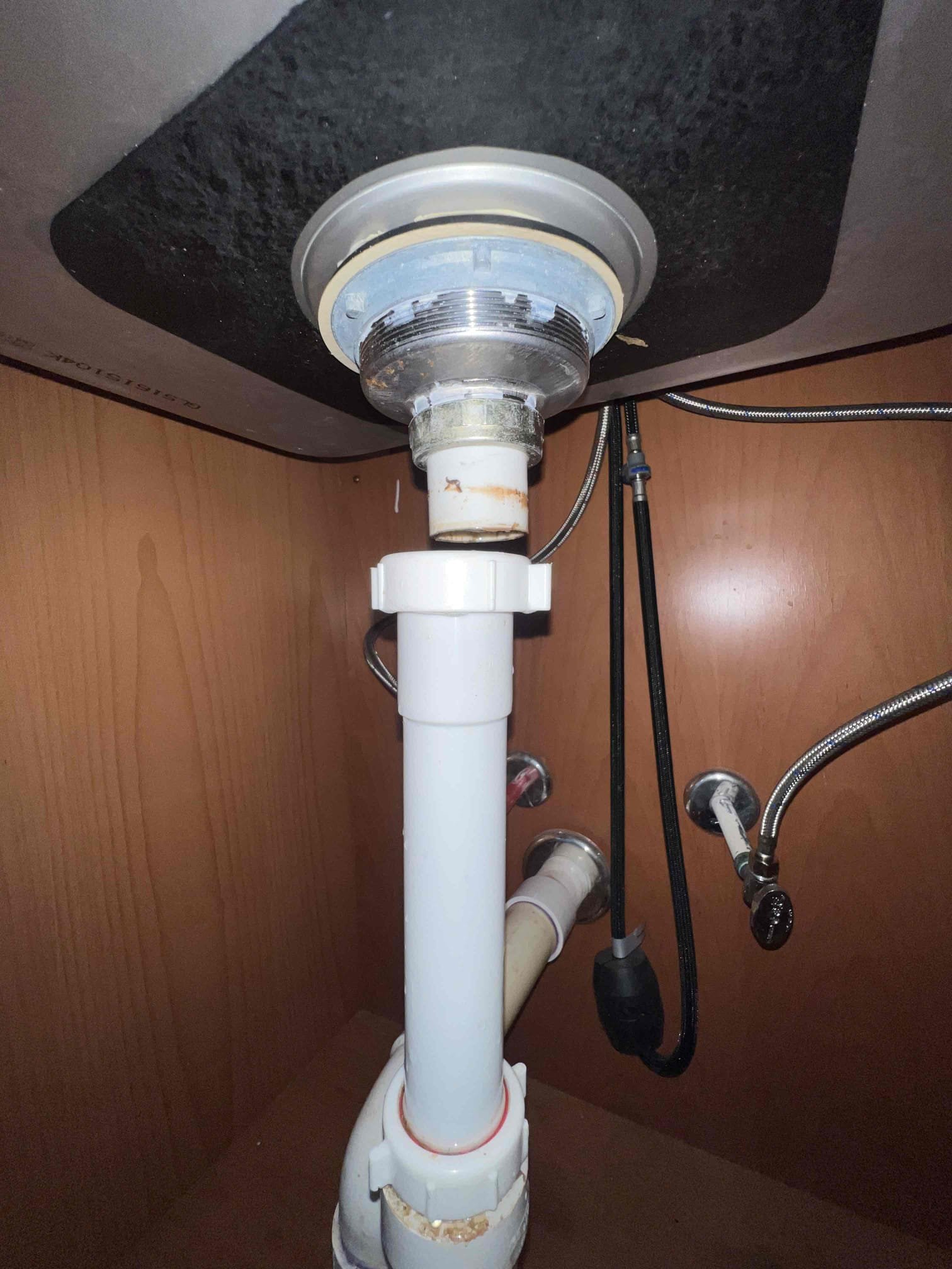 Arrived on site client stated his hose got stuck on the hose bib and he couldn’t take it off and he has a leak under the kitchen sink. Upon inspection the flange tailpiece was disconnected from the basket strainer. As a courtesy we removed the hose connection from the bib outside. Replaced the flange tailpiece along with the glue trap under the kitchen sink and replaced it with tubular trap and tubular tailpiece. Tested for leaks when done with hot water and there are no leaks at this time.