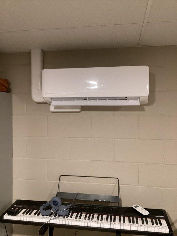 Performed second phase of refrigerant leak investigation by conducting UV dye inspection on mini-split heat pump system. Located leak at connection fitting between refrigerant lines using ultraviolet detection method. Verified that previously injected sealant has begun addressing the leak, with evidence of proper sealing at the connection point.