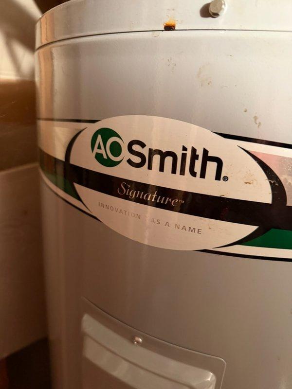 Inspected A.O. Smith Signature water heater reporting leakage at base. Performed visual examination of tank exterior and plumbing connections. Identified and repaired leak at copper pipe fitting junction where corrosion had developed, resolving the issue without need for tank replacement.