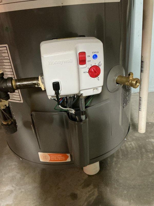 Responded to service call for a Rheem 50-gallon natural gas water heater reported to be leaking from the drain valve area. Upon inspection, identified internal drain valve failure as the source of leakage rather than tank corrosion. Replaced defective drain valve and verified proper operation of the Honeywell control unit, ensuring system was functioning correctly before customer's scheduled departure.