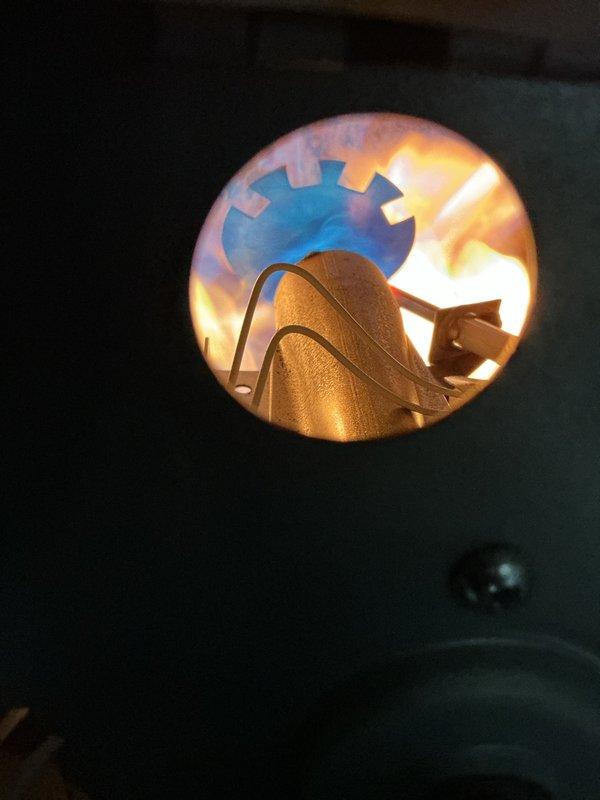 Responded to no-heat call for propane furnace that was attempting to start but failing to ignite properly. Inspection revealed ignition system issues, successfully cleaned and adjusted burner assembly to restore proper flame pattern. System now operating normally with strong blue/orange flame visible through inspection port.