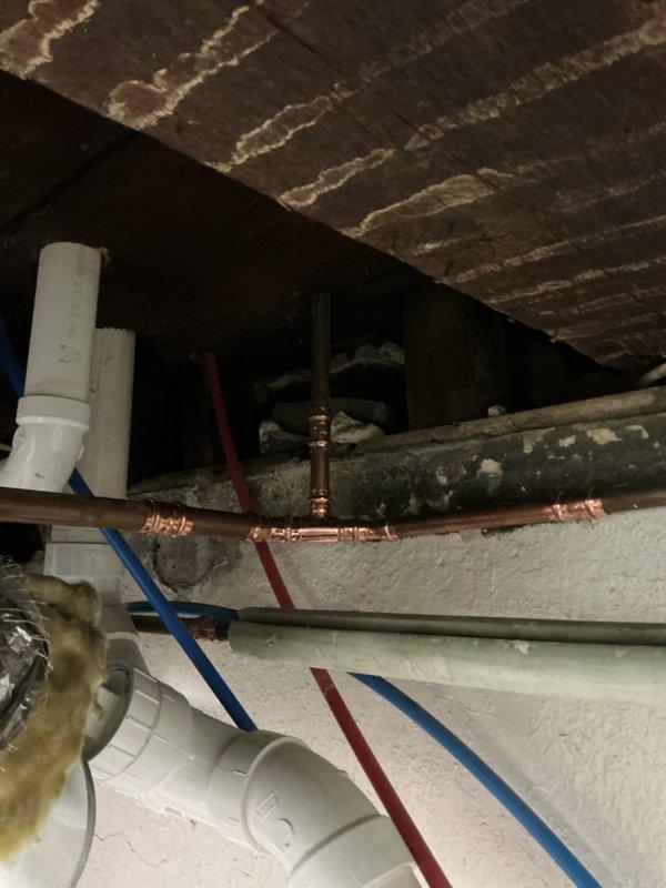 # Heating System Repair - Dining Room Baseboard Loop

Drained the heating loop serving the dining room baseboard unit to address reported leaks. Inspected all fittings and connections along the affected zone, including the brass control valve assembly and associated piping. Repaired leaking fittings by tightening connections and replacing compromised components as needed. Verified integrity of copper piping runs in basement where the loop originates, checking all T-joints and brass fittings for proper sealing. Refilled the heating loop, purged air from the system, and pressure-tested all repaired connections to ensure leak-free operation. Confirmed proper flow through the baseboard unit and verified control valve functionality before returning system to service.