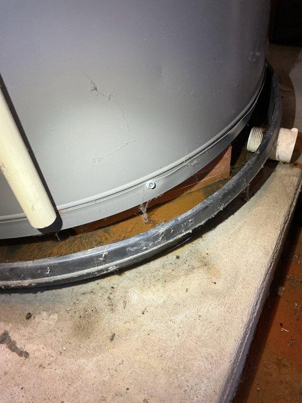 Responded to emergency call for water heater leak in basement utility area. Upon arrival, found active water seepage from water heater tank causing significant moisture damage to concrete floor with visible efflorescence and mineral deposits throughout the area. Assessed water heater condition, documented extensive floor staining and water accumulation, and identified compromised tank integrity as source of leak. Provided customer with repair options and recommendations for water heater replacement due to tank failure.