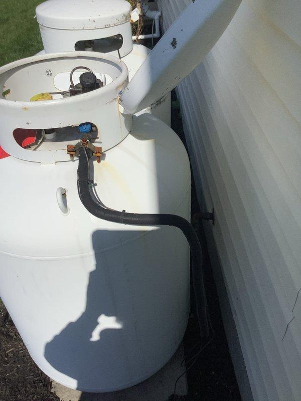 Responded to follow-up service call to repair gas leak on propane supply line from tank to house after propane delivery company identified and red-tagged the system. Repaired corroded gas piping connections and replaced deteriorated fittings on exterior propane line assembly, addressing leak points that had prevented system operation. Pressure tested repaired gas line to verify integrity, restored system to safe operating condition, and documented equipment condition with photographs showing exterior piping and HVAC components.