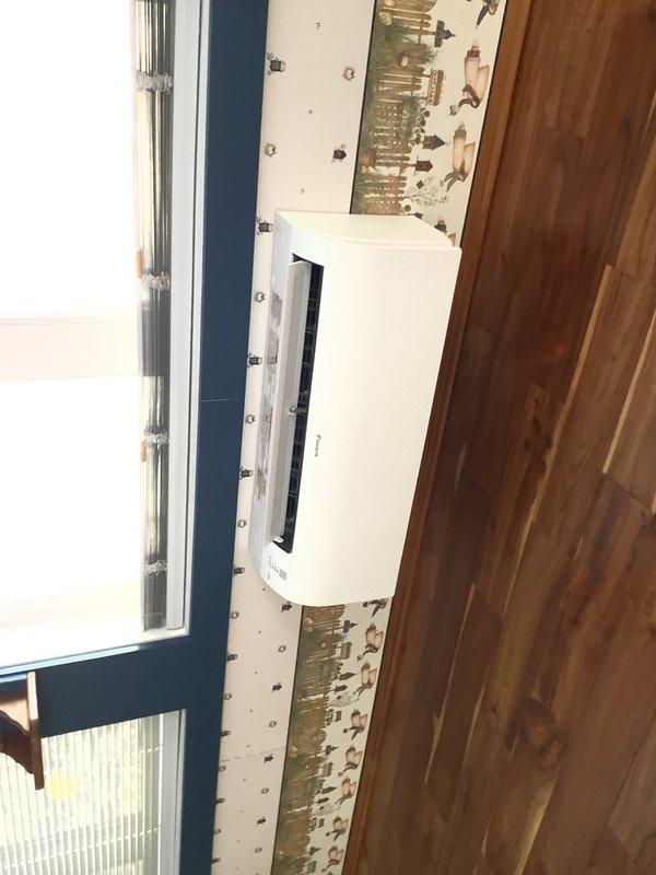 Completed installation of Daikin Aurora ductless heat pump system for sunroom application. Mounted indoor air handler unit on interior wall, installed outdoor disconnect box with proper electrical connections, and commissioned system for operation.