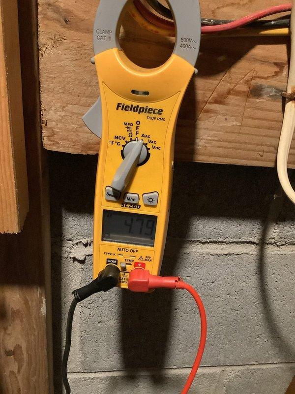 Completed stage 2 renovation work involving baseboard removal and reinstallation. Investigated large pipe with temporary cloth blockage to determine its function, confirming it serves as a drainage conduit during heavy rainfall events. Replaced oil burner nozzle with 65x70B specification unit and performed electrical system diagnostics using clamp meter to verify proper operation of heating controls and transformer assembly.