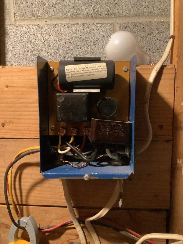 Completed stage 2 renovation work involving baseboard removal and reinstallation. Investigated large pipe with temporary cloth blockage to determine its function, confirming it serves as a drainage conduit during heavy rainfall events. Replaced oil burner nozzle with 65x70B specification unit and performed electrical system diagnostics using clamp meter to verify proper operation of heating controls and transformer assembly.