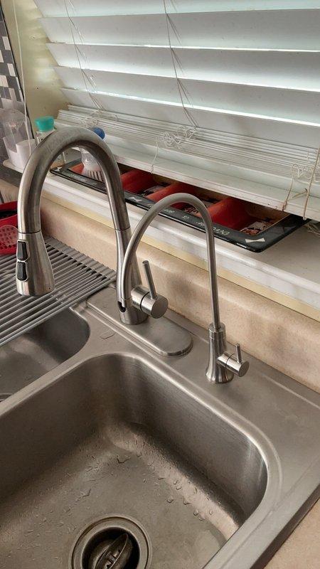 Installed new Elkay beverage faucet at kitchen sink location. Mounted faucet assembly adjacent to existing primary kitchen faucet on undermount stainless steel sink basin. Connected water supply line to ensure proper flow and pressure for beverage dispensing applications. Tested installation for leaks and verified operational functionality of all components. Installation complete with dual faucet configuration now operational at sink workstation.