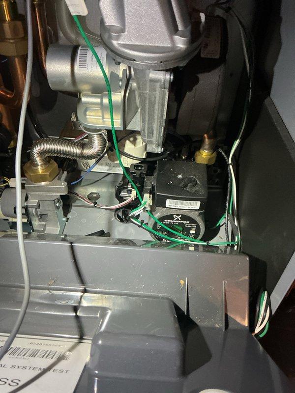 Responded to service call for Burnham Altac propane combi boiler experiencing thumping noise during operation that ceases when domestic hot water is activated. Performed diagnostic inspection of unit installed in April 2025. Inspected internal components including blower motor assembly, heat exchanger, three-way valve operation, and control board functionality. Reviewed manufacturer troubleshooting guide to identify potential causes related to water flow, air in system, and valve cycling. Documented system operation and captured images of internal components and diagnostic reference materials for further analysis.