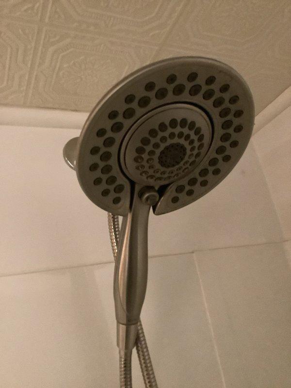 Responded to service call for two plumbing issues: a Moen center lever shower valve that was leaking and difficult to operate, and a leaking shut-off valve for the washing machine connection. Retrieved necessary parts from warehouse inventory and completed repairs. Replaced the problematic Moen shower valve assembly with a new Delta handheld shower fixture, which was installed with flexible metal braided hose connection. The new unit features a brushed nickel finish and ergonomic design for improved operation and water control. Addressed the washing machine shut-off valve leak by replacing the faulty middle lever valve. Both fixtures were tested for proper operation and verified leak-free performance before completing the service call.