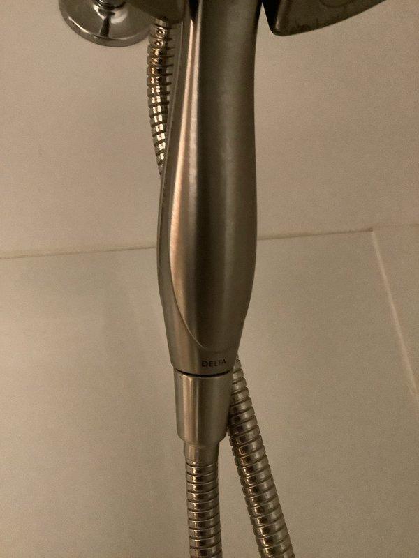 Responded to service call for two plumbing issues: a Moen center lever shower valve that was leaking and difficult to operate, and a leaking shut-off valve for the washing machine connection. Retrieved necessary parts from warehouse inventory and completed repairs. Replaced the problematic Moen shower valve assembly with a new Delta handheld shower fixture, which was installed with flexible metal braided hose connection. The new unit features a brushed nickel finish and ergonomic design for improved operation and water control. Addressed the washing machine shut-off valve leak by replacing the faulty middle lever valve. Both fixtures were tested for proper operation and verified leak-free performance before completing the service call.