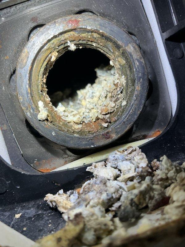 Responded to no hot water complaint on electric water heater installed between 2012-2015. Found tripped circuit breaker at main electrical panel and reset to restore power. Upon further inspection, identified limited hot water production indicating failing heating elements. Unit located in confined space with inadequate lighting, requiring auxiliary illumination for proper assessment. Observed severe mineral buildup and sediment accumulation on heating element, consistent with hard water conditions and lack of water softening system. Heavy scale deposits noted, indicating chronic hard water damage contributing to repeated element failures. Documented electrical panel condition and heating element deterioration with photographs. Advised property owner that heating elements require replacement due to mineral scaling, marking the fourth replacement cycle for this unit, and strongly recommended installation of water softening system to prevent continued premature element failure and extend
