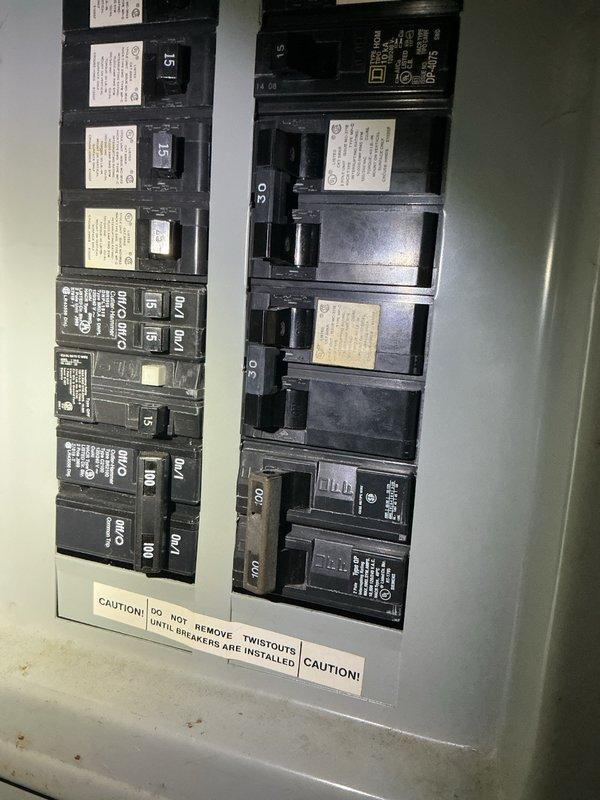 Responded to no hot water complaint on electric water heater installed between 2012-2015. Found tripped circuit breaker at main electrical panel and reset to restore power. Upon further inspection, identified limited hot water production indicating failing heating elements. Unit located in confined space with inadequate lighting, requiring auxiliary illumination for proper assessment. Observed severe mineral buildup and sediment accumulation on heating element, consistent with hard water conditions and lack of water softening system. Heavy scale deposits noted, indicating chronic hard water damage contributing to repeated element failures. Documented electrical panel condition and heating element deterioration with photographs. Advised property owner that heating elements require replacement due to mineral scaling, marking the fourth replacement cycle for this unit, and strongly recommended installation of water softening system to prevent continued premature element failure and extend