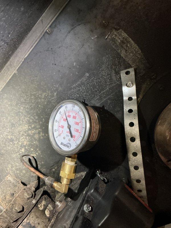 Responded to no heat call on existing oil heating system for new customer with unit approximately 12-14 years old. Initial service visit required rescheduling to accommodate customer availability. Upon arrival, verified oil tank levels and assessed system operation. Installed and tested pressure gauge on heating system, confirming proper operating pressures. System restored to normal operation with heat functioning properly.