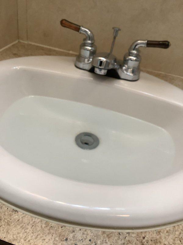 Responded to service call for bathroom sink pop-up drain assembly issue. Upon arrival, inspected existing chrome pop-up drain with gray stopper and two-handle faucet assembly. Assessed whether drain nut could be replaced or if complete pop-up assembly replacement was necessary. Tested drain operation and water flow to determine extent of repair needed. Also evaluated existing Briggs toilet for potential rebuild and provided pricing information for comfort height toilet replacement option per customer request.