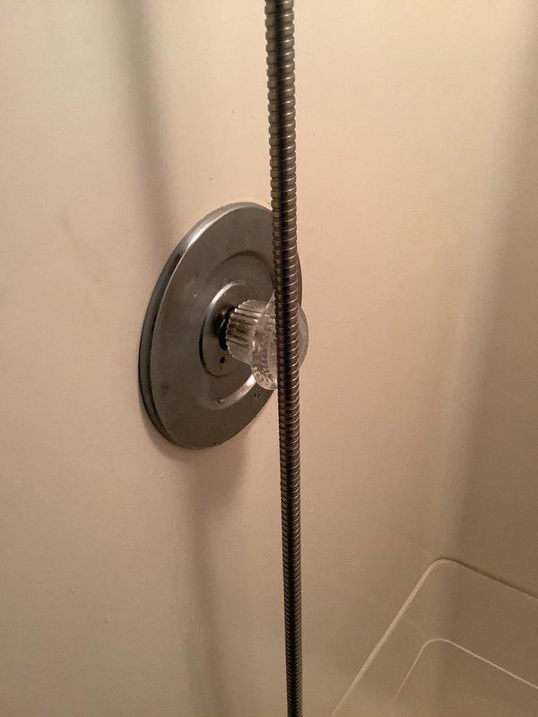 Responded to emergency no-water situation where family room shower could not be shut off after use. Upon inspection, discovered faulty shower valve assembly lacking dedicated shutoff valve. Removed defective shower diverter mechanism and cartridge assembly from wall-mounted fixture. Replaced malfunctioning valve components with new cartridge and escutcheon plate. Restored water control functionality to shower, allowing household water system to be safely reactivated. Verified proper operation of handheld shower attachment and tested for leaks at all connection points.