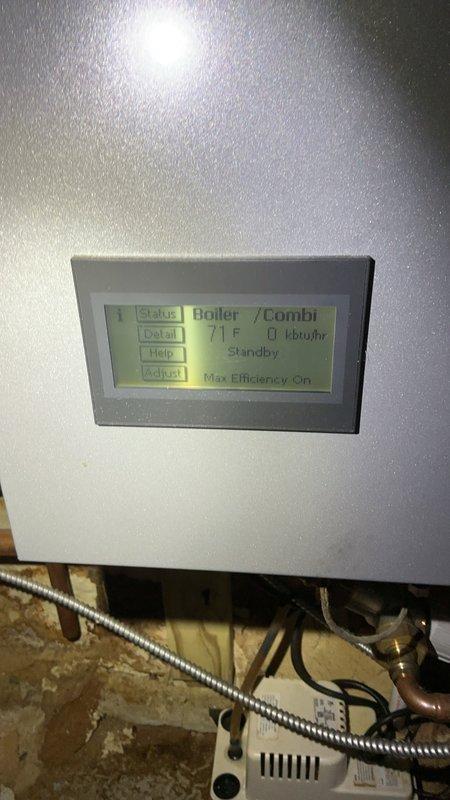 Responded to no domestic hot water complaint on combination boiler system. Upon arrival, found unit in standby mode displaying 71°F and 0 kbtu/hr on digital control panel with max efficiency setting enabled. Inspected boiler piping configuration including copper supply and return lines, yellow-handled isolation valves, and associated pressure regulation components. Diagnosed issue preventing domestic hot water production while heating system remained operational. Evaluated control board status indicators and verified system parameters on LCD display. Examined plumbing connections at boiler manifold including brass fittings and ball valves serving both heating and domestic hot water circuits. Performed necessary repairs to restore domestic hot water functionality. Cycled system through complete operational test to confirm proper heating and hot water production. Verified all safety controls operating within normal parameters. Unit left in full working condition with both heating and dom