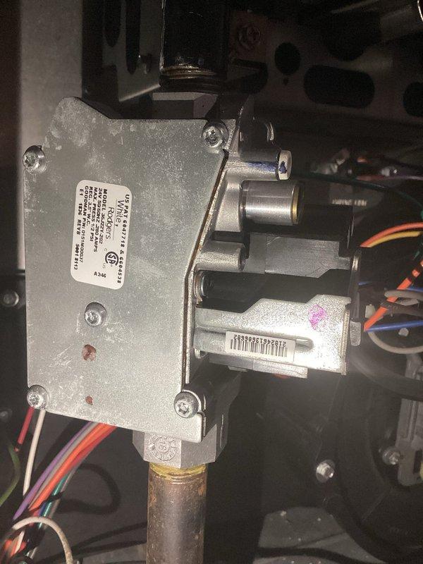 Responded to service call for natural gas Amana heating system with intermittent operation issues. Customer reported unit was cycling on and off sporadically, and after previous thermostat replacement provided temporary resolution, system now fails to initiate heating cycle entirely. Upon arrival, performed diagnostic assessment of heating system including inspection of gas valve assembly, control board wiring connections, and external gas supply line. Verified natural gas supply at exterior meter connection point and confirmed proper gas flow to unit. Examined gas valve control module and associated electrical connections, noting multiple wire terminations to valve assembly. Inspected thermostat communication circuit and verified proper voltage at control board. Documented equipment condition through photographic evidence of gas valve assembly and exterior gas meter connection. System evaluation revealed potential issues with gas valve operation or control board signal communication p