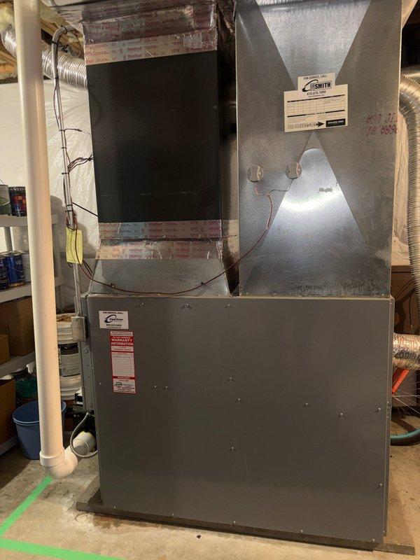 Completed comprehensive heat pump maintenance and system inspection on existing equipment. Performed heating mode tune-up including visual inspection of indoor air handler unit, ductwork connections, and electrical components. Verified proper operation of heat pump system while oil backup heating system was not serviced during this visit. Documented equipment condition with photographs showing basement installation environment and overall system configuration.