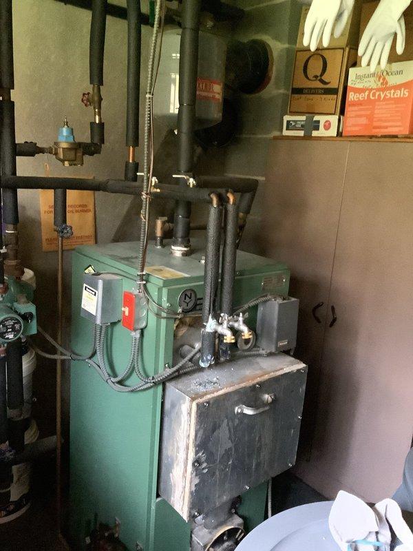 Responded to no hot water complaint on oil-fired boiler system. Upon arrival, inspected boiler unit and associated hydronic piping system. Found low system water pressure affecting boiler operation. Checked expansion tank, circulator, and zone valves for proper function. Addressed water pressure issue by adding water to system and purging air from lines. Verified boiler firing sequence, burner operation, and flame characteristics. Confirmed domestic hot water production restored and system operating within normal parameters. Advised customer regarding low water pressure throughout house plumbing system requiring attention to house water filter.