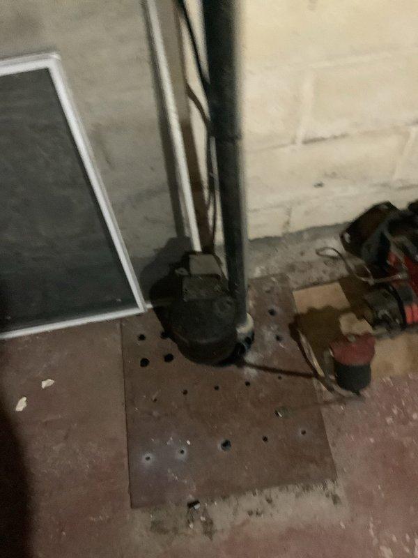Responded to service call for outdoor faucet at rear of property experiencing leakage and stiff handle operation following winter freeze conditions. Upon inspection, determined that frost damage had compromised the hose bibb assembly, causing internal seal deterioration and stem binding. Accessed supply lines through basement utility area to assess extent of damage and verify proper shutoff capability. Documented existing conditions showing utility piping configuration and access points for future reference. Recommended replacement of freeze-damaged exterior faucet with frost-proof sillcock to prevent recurrence of cold weather failures.