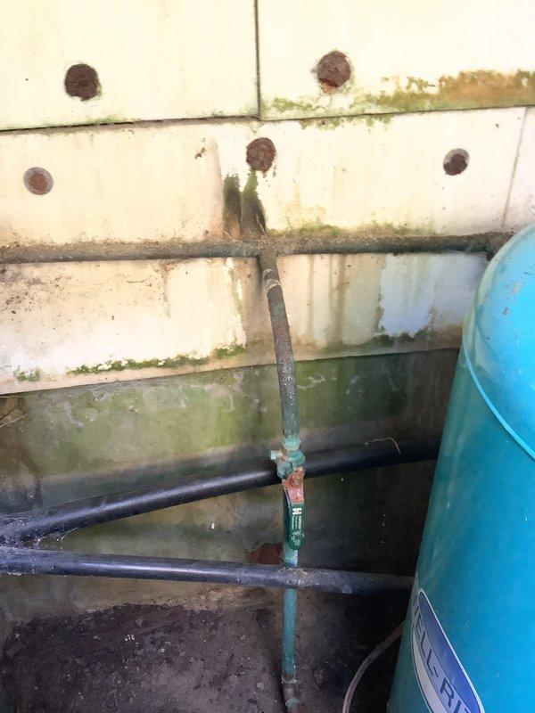 Responded to service call for well water system experiencing intermittent pressure loss. Customer had temporarily resolved issue by resetting breaker, indicating potential electrical component failure. Inspected well pump system and electrical connections at exterior utility area, documenting existing equipment condition including weathered piping and pressure tank installation. Advised customer that breaker tripping pattern suggests pump motor drawing excessive current, likely due to failing capacitor, worn impeller, or motor bearing issues requiring further diagnostic testing and potential pump replacement to achieve permanent resolution.