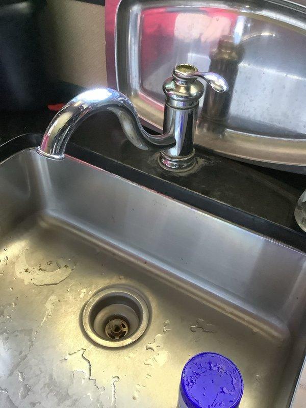 Replaced leaking kitchen faucet with new chrome-finished single-handle unit on stainless steel sink. Replaced lavatory faucet in first-floor powder room and cleared clogged drain to restore proper function.