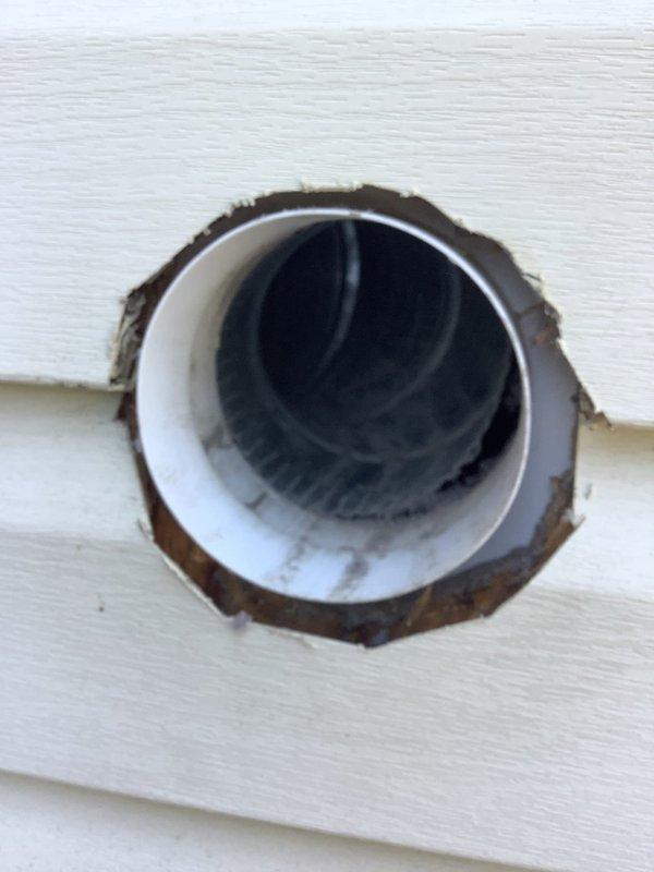 Completed first floor dryer vent cleaning on a short-run system. Upon inspection, discovered significant rust and corrosion around the exterior vent collar where it meets the siding, along with lint and debris accumulation visible inside the vent pipe. Recommended pipe replacement due to deteriorated condition of the exhaust termination point.