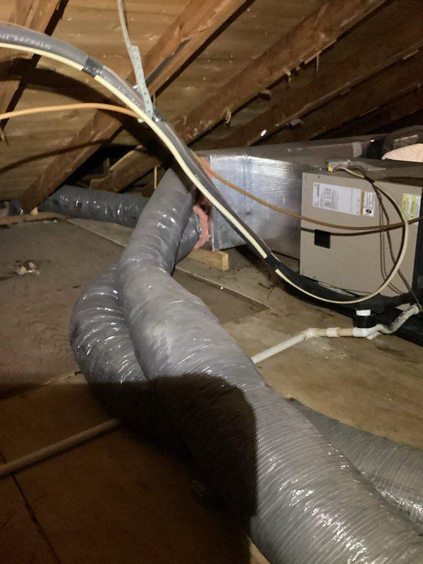Responded to no cooling complaint on heat pump system. Found indoor evaporator coil completely iced over while both indoor and outdoor units were running. Instructed customer to turn system off and run fan only mode to allow coil to thaw completely. Inspected attic installation and ductwork system during visit. Customer reported recent filter change but uncertain of unit age and previous service history. System requires follow-up after thaw cycle to diagnose root cause of icing condition, which may include low refrigerant charge, restricted airflow, or failed components.