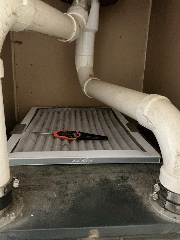 Completed comprehensive air conditioning tune-up and maintenance inspection for residential HVAC system that had not been serviced since 2018. Performed system diagnostics to address reported cooling efficiency concerns, including temperature differential measurements across the air handler unit. Inspected air filtration system, noting AmazonBasics pleated filter in place with moderate dust accumulation; verified proper filter installation and airflow pathway. Examined condensate drainage system including PVC piping configuration and drain pan, observing moisture staining and sediment deposits in collection tray indicating normal system operation but recommending periodic cleaning to prevent potential blockages. Evaluated all accessible air handler components within utility closet installation, confirming proper mounting and clearances for maintenance access. System operational at time of inspection with all major components functioning as designed.