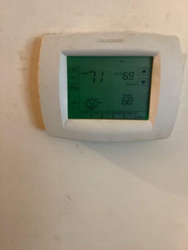 Responded to service call for Rheem heat pump system experiencing reduced cooling capacity. Upon arrival, confirmed unit was blowing cool air but not maintaining temperature setpoint as indicated on Honeywell thermostat. Performed diagnostic inspection of 2013 heat pump system located in attic, which had not received maintenance service since 2019, and documented equipment condition with photos of outdoor condenser unit and indoor thermostat display showing temperature differential.