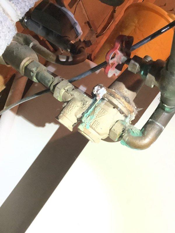 Responded to service call for small water leak in laundry room plumbing. Upon inspection, identified aging pressure reducing valve (PRV) with visible corrosion and mineral deposits on brass components, indicating potential failure point causing leak. Replaced deteriorated PRV with new valve assembly, ensuring proper installation and connection integrity. Conducted comprehensive water quality testing including hardness, pH, and iron levels to assess system conditions. Inspected toilet mechanism for intermittent running issue, identified faulty fill valve components contributing to cycling problem. Documented existing plumbing conditions with photographs showing corroded brass fittings and aged copper piping with green patina, typical of older installations. All repairs completed and system restored to proper working order with no active leaks detected upon final inspection.