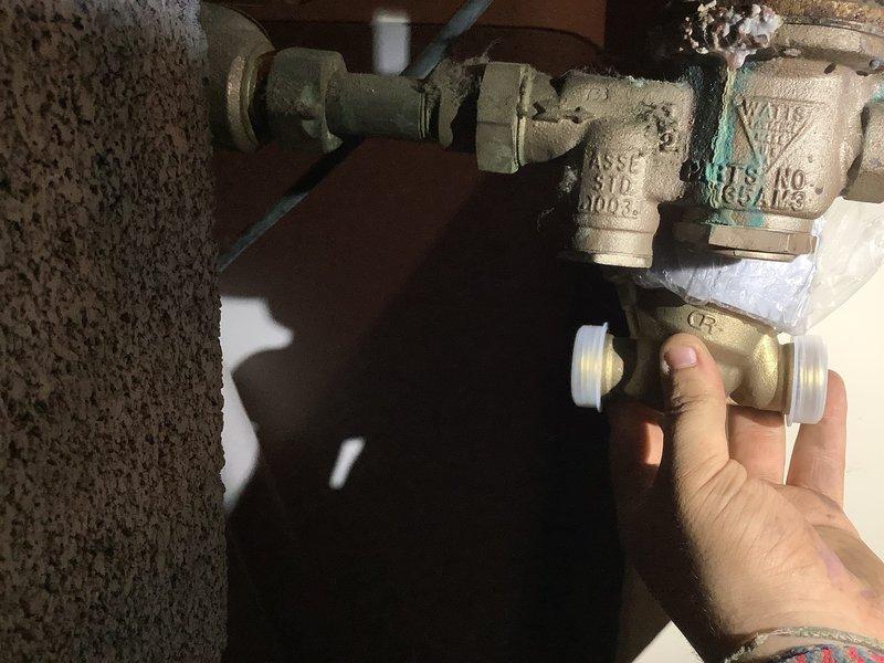 Responded to service call for small water leak in laundry room plumbing. Upon inspection, identified aging pressure reducing valve (PRV) with visible corrosion and mineral deposits on brass components, indicating potential failure point causing leak. Replaced deteriorated PRV with new valve assembly, ensuring proper installation and connection integrity. Conducted comprehensive water quality testing including hardness, pH, and iron levels to assess system conditions. Inspected toilet mechanism for intermittent running issue, identified faulty fill valve components contributing to cycling problem. Documented existing plumbing conditions with photographs showing corroded brass fittings and aged copper piping with green patina, typical of older installations. All repairs completed and system restored to proper working order with no active leaks detected upon final inspection.