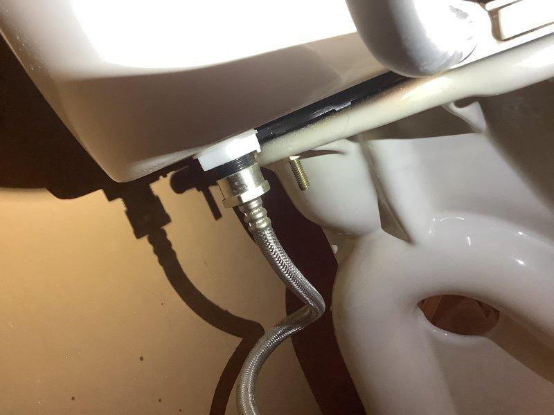 Responded to after hours emergency for leaking toilet. Replaced defective tank-to-bowl gasket with part retrieved from warehouse shelf and installed new mounting bracket using gasket from truck stock. Leak eliminated and fixture restored to proper operation.