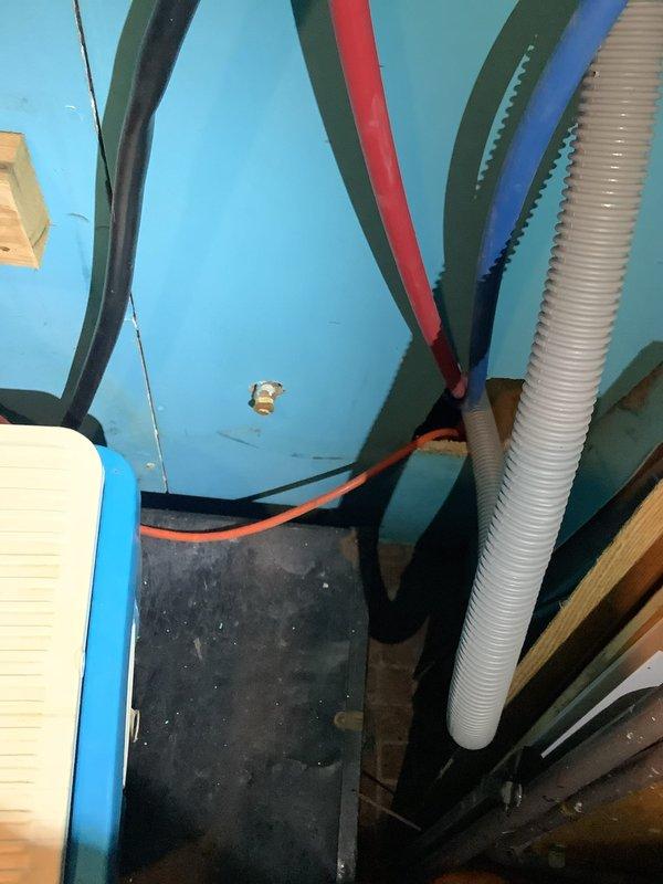 Responded to emergency callback for kitchen sink clog that escalated to active water leak beneath cabinet and onto floor. Addressed warranty issue with washing machine drain connection installed previously, which developed a small leak. Inspected plumbing assembly including valve system with dual shut-off controls, flexible corrugated supply lines, and drainage connections in utility area. Repaired leaking drain line, secured all connections, and verified proper water flow to resolve both the cabinet leak and washer drain issue.