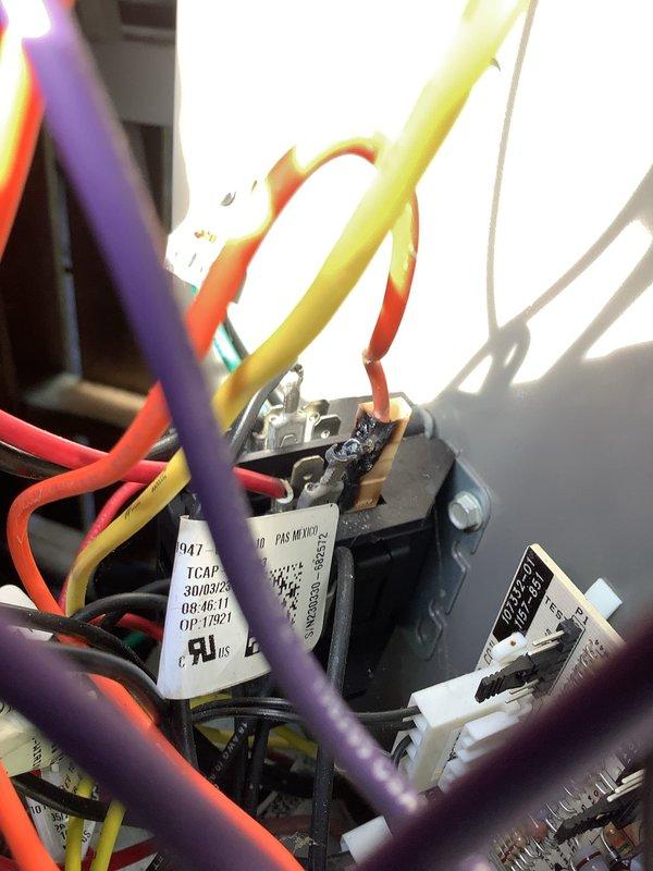 Responded to no cooling complaint on residential AC system. Customer reported unit went down overnight with no cool air output despite system running after restart. Upon arrival, inspected electrical components including control board, capacitor, and relay assembly. Examined wire connections at multiple terminals showing red, yellow, white, purple, and orange conductors. Verified proper connections at capacitor terminals and contactor assembly. Reviewed system service history noting previous issues with this unit. Performed diagnostic evaluation of control circuitry and electrical components to identify cause of cooling failure. Documented component conditions with photos of control board assembly and capacitor/relay configuration for service records.