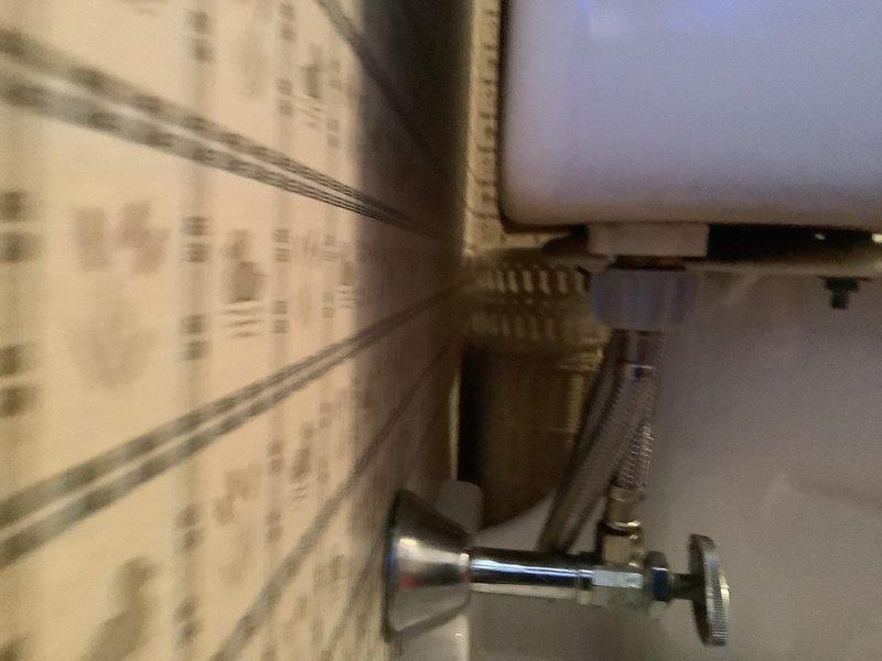 Responded to after-hours emergency for reported toilet leak. Upon arrival, inspected bathroom plumbing fixtures and identified water seepage from toilet supply line connection at the angle stop valve. Tightened compression fitting on braided supply line and verified all connections at the chrome shut-off valve were secure. Tested system by cycling water supply and flushing toilet multiple times to confirm leak was resolved with no further water discharge observed.
