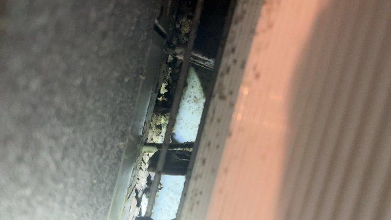 Completed preventive maintenance inspection on Daikin mini-split heat pump system installed in 2018. Accessed indoor air handler unit, inspected internal components including evaporator coil assembly, blower housing, and filter compartments. Noted moderate dust and debris accumulation on metal framework, perforated mounting brackets, and ductwork surfaces indicating need for cleaning during service. Documented equipment condition through photographic inspection showing operational components and overall system status for maintenance records.