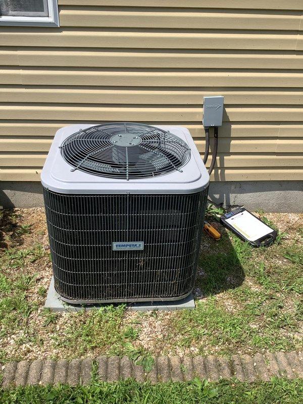Responded to service call regarding excessive moisture accumulation requiring daily removal of approximately one bucket of water from HVAC system. Upon inspection, identified clogged condensate drain P-trap as the likely cause of water leakage around seal area. Documented Tempstar outdoor condenser unit and Thermo brand blower assembly with photos for service records.