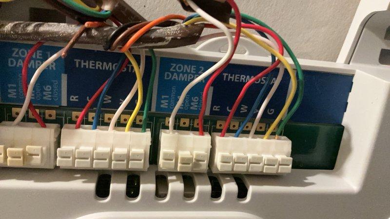 Serviced multi-zone HVAC system by installing and wiring zone damper control panel with multiple zone modules and thermostat connections. Verified proper operation of all zone dampers and confirmed system functionality in attic installation area.