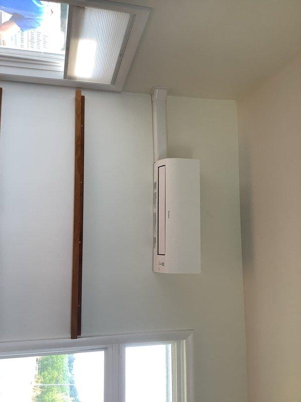 Completed installation of two Daikin ductless heat pump systems: Aurora and Oterra models. Indoor wall-mounted air handler installed in upper-level room with vertical line set concealment and proper integration with existing skylight configuration. Outdoor condensing unit positioned and connected with refrigerant lines, verified system pressures at 99 PSI during startup and commissioning. All electrical connections, drainage, and refrigerant charging completed to manufacturer specifications, with system tested and operational.