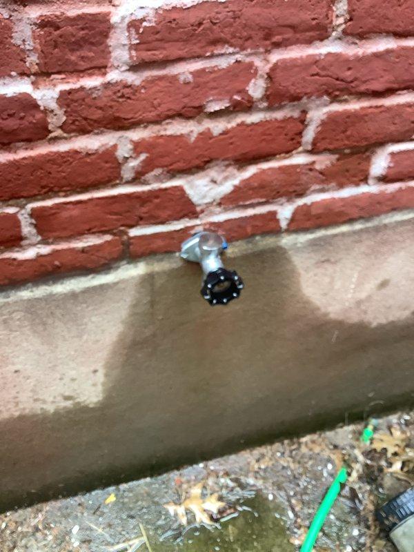 Responded to service call for outdoor hose bib that was not winterized and suspected to have frozen damage. Inspected exterior wall-mounted hydrant fixture at foundation level where brick meets concrete slab. Confirmed freeze damage to spigot assembly from water left in line during winter months. Removed damaged hose bib, replaced with new frost-free sillcock unit, and secured mounting hardware to brick wall. Tested new fixture for proper operation and verified no leaks at connection points.