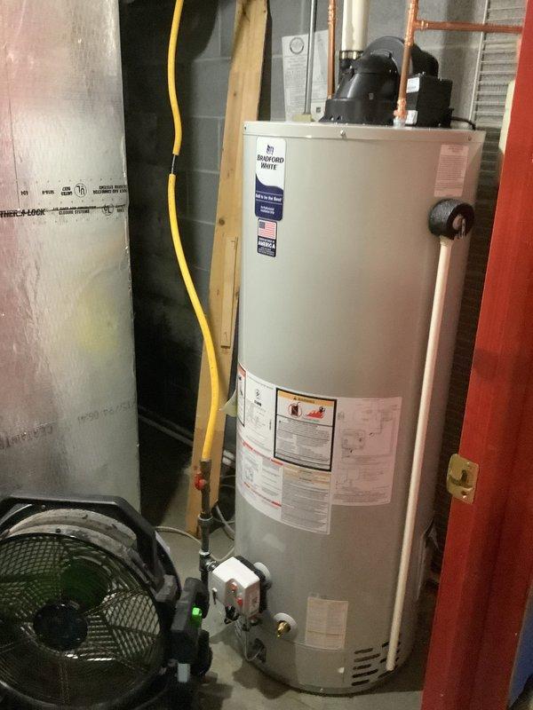 Replaced leaking natural gas power vent water heater with new unit, including installation of new expansion tank. The original water heater was failing at the base, necessitating complete replacement. Connected all necessary utilities including gas line, copper water supply lines, and PVC venting. Exercise caution with existing valve on top of old unit due to corrosion concerns to prevent additional water damage during removal.